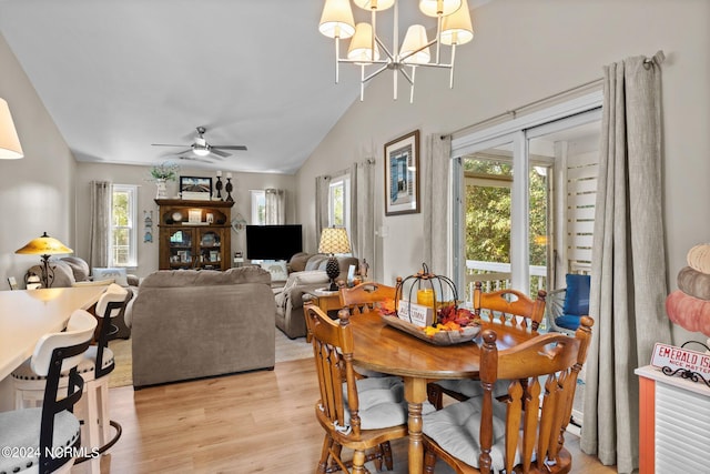 dining area with light wood-type flooring, vaulted ceiling, and ceiling fan with notable chandelier