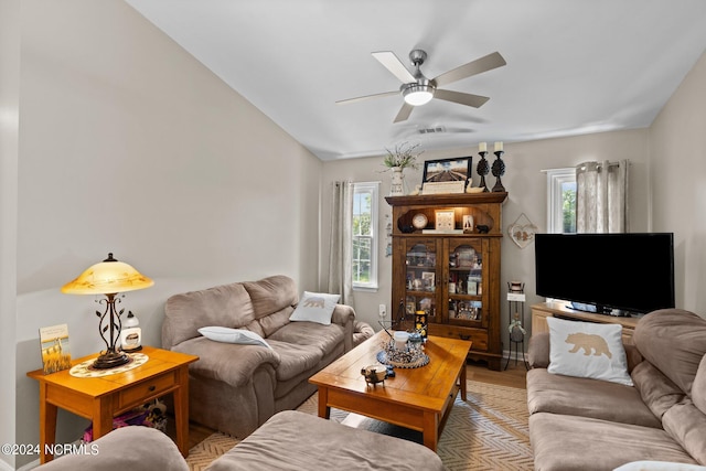 living room with ceiling fan, wood-type flooring, and lofted ceiling