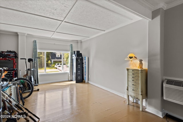 workout room with a drop ceiling and light wood-type flooring