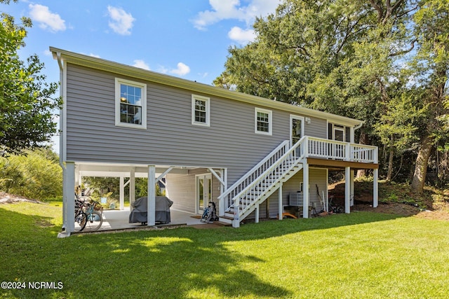 back of house with a deck, a patio, and a lawn