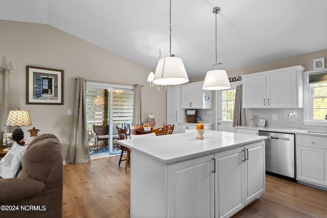 kitchen with tasteful backsplash, vaulted ceiling, light hardwood / wood-style floors, and dishwasher