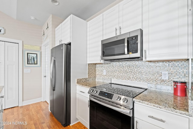 kitchen with appliances with stainless steel finishes, white cabinetry, and tasteful backsplash