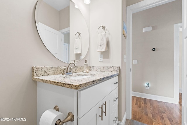 bathroom with wood finished floors, vanity, and baseboards