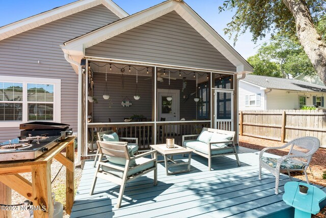 deck featuring an outdoor living space and a sunroom