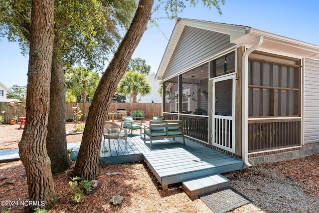 exterior space featuring a sunroom and fence