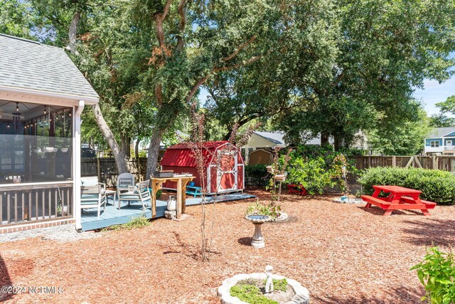 view of yard with a sunroom, a shed, and a deck