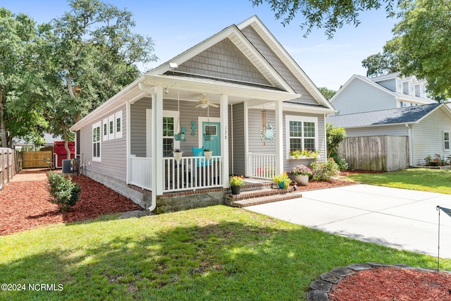 view of front of house featuring a porch, central AC, fence, a ceiling fan, and a front yard