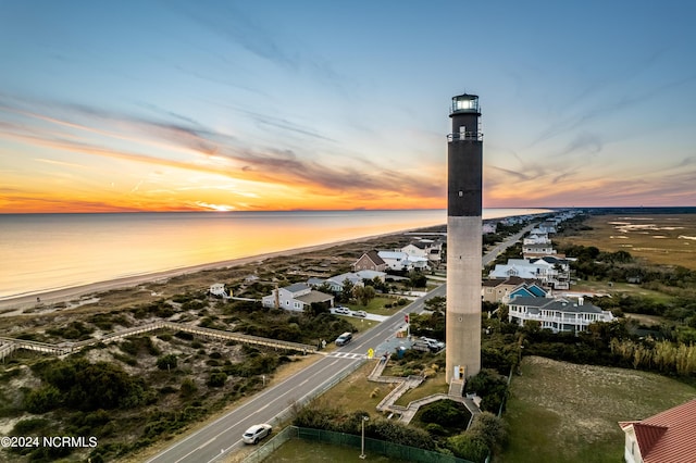 aerial view at dusk featuring a beach view and a water view