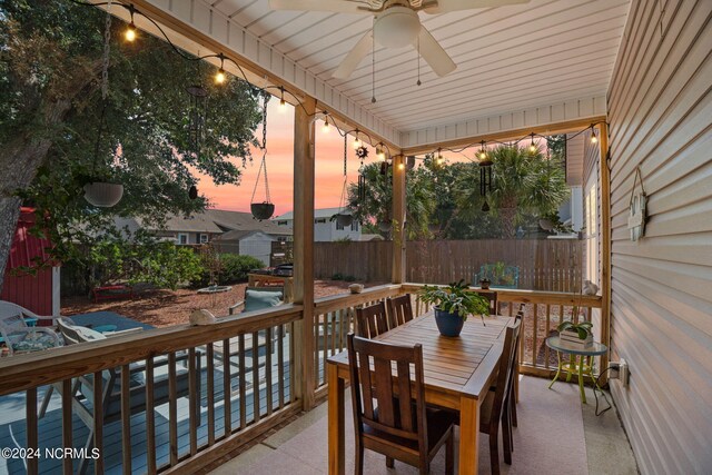 deck at dusk featuring ceiling fan