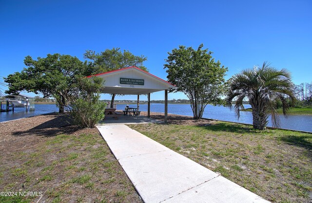 dock area featuring a lawn and a water view