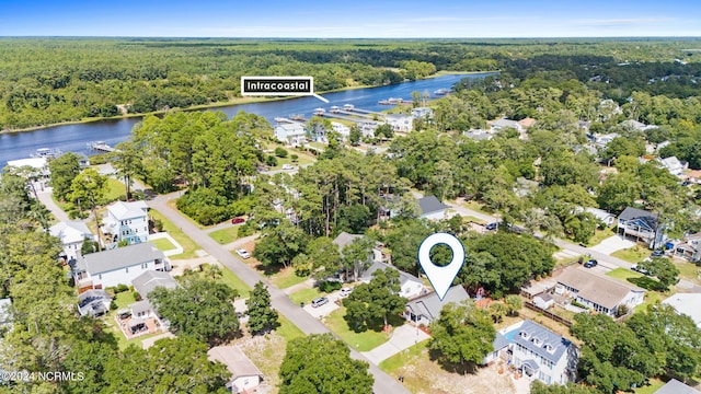 birds eye view of property with a water view, a wooded view, and a residential view