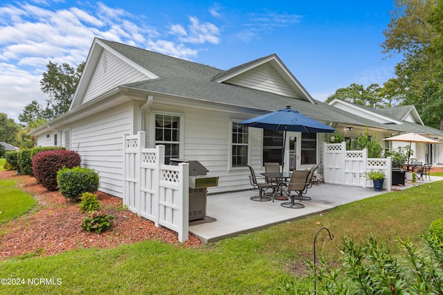 rear view of house featuring a lawn and a patio area