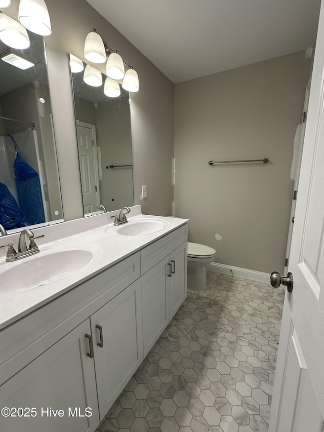 bathroom featuring tile patterned flooring, vanity, and toilet