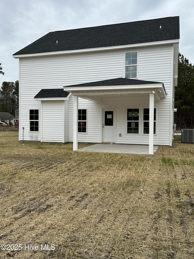 back of house with central AC unit, a patio area, and a lawn