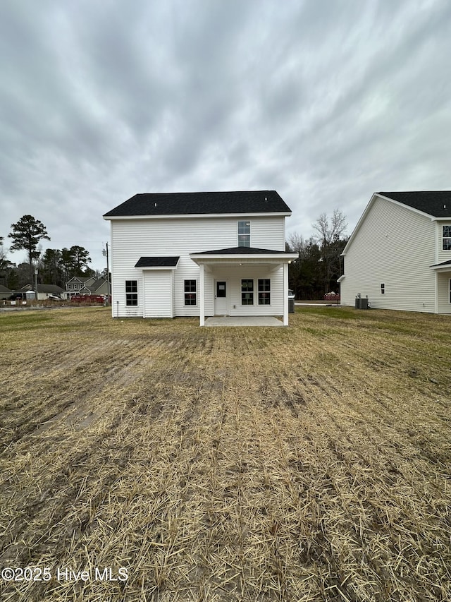 rear view of house featuring a patio area and a yard