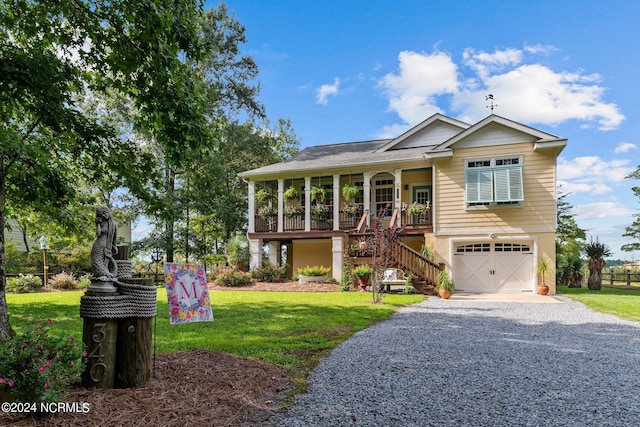 view of front of property with a garage, covered porch, and a front yard