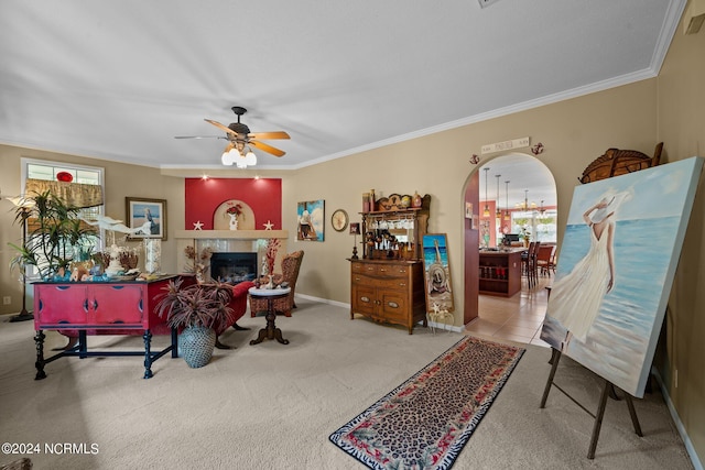 living room featuring crown molding, ceiling fan, and light colored carpet