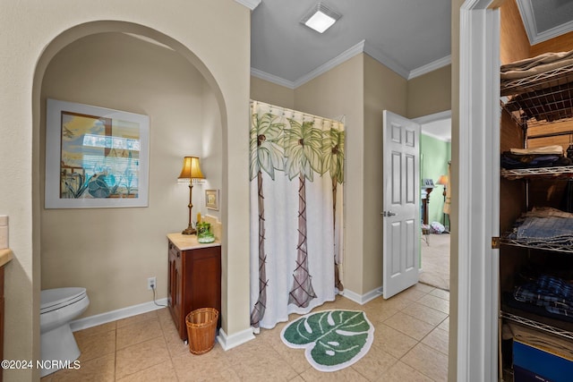 bathroom with crown molding, vanity, toilet, and tile patterned flooring