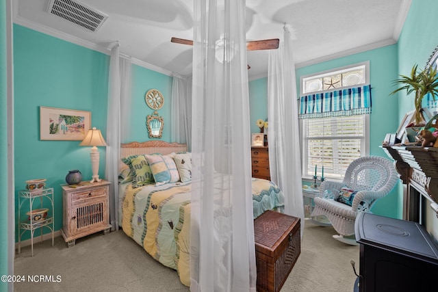 carpeted bedroom with ornamental molding and ceiling fan