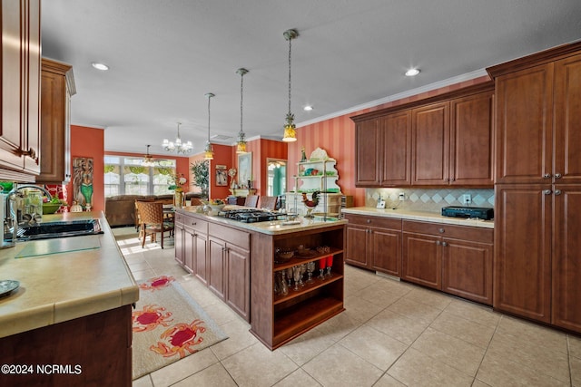 kitchen featuring a kitchen island, an inviting chandelier, decorative light fixtures, crown molding, and sink