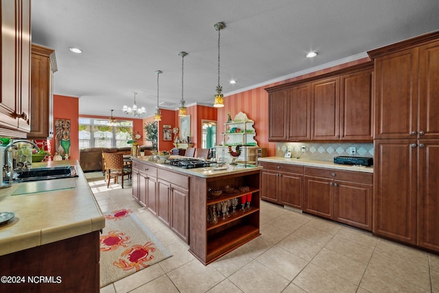 kitchen featuring a kitchen island, ornamental molding, light countertops, a sink, and black gas stovetop