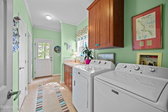 clothes washing area featuring washing machine and clothes dryer, light tile patterned floors, cabinet space, ornamental molding, and baseboards