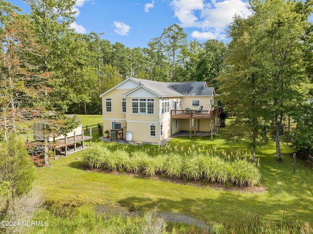 rear view of house featuring central air condition unit, a lawn, a patio, and a deck