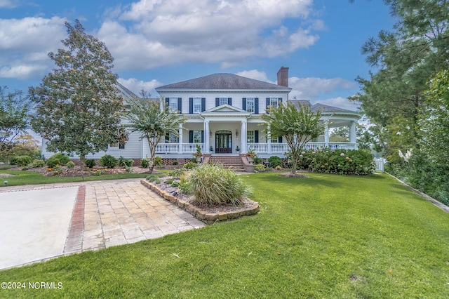 view of front of house with a front yard and covered porch