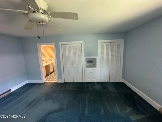 unfurnished bedroom featuring carpet, multiple closets, connected bathroom, and ceiling fan