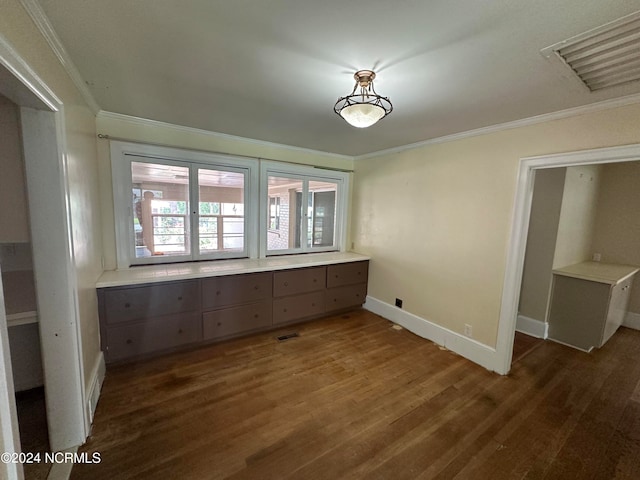 unfurnished bedroom featuring crown molding and dark wood-type flooring