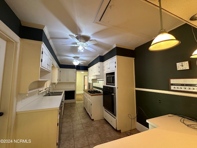 kitchen featuring hanging light fixtures, appliances with stainless steel finishes, sink, crown molding, and dark tile patterned floors