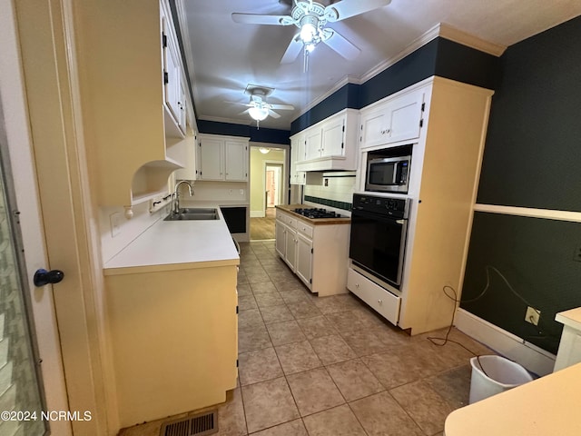 kitchen with black oven, sink, stainless steel microwave, light tile patterned floors, and ceiling fan