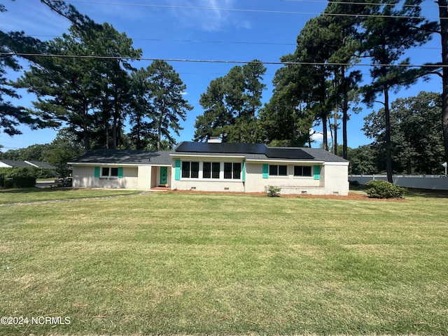 view of front of house featuring solar panels and a front lawn