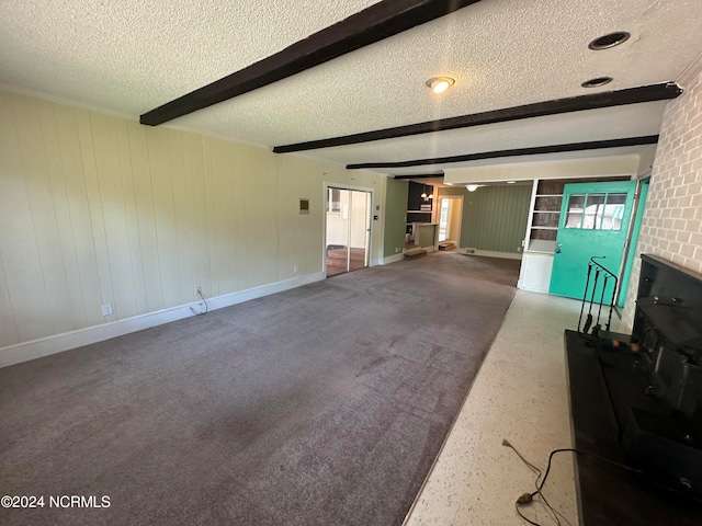 unfurnished living room featuring carpet flooring, a textured ceiling, and beamed ceiling