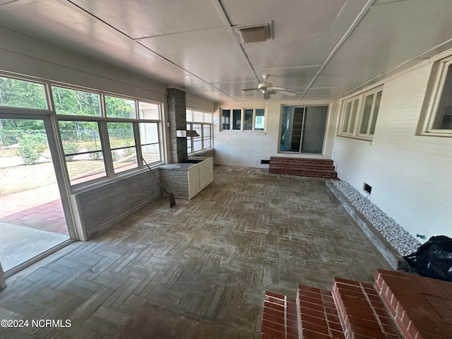 unfurnished sunroom with ceiling fan