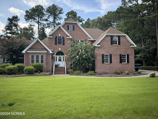 view of front of house with a front lawn and brick siding