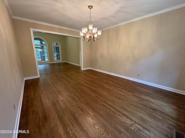 spare room featuring crown molding, an inviting chandelier, and dark hardwood / wood-style floors