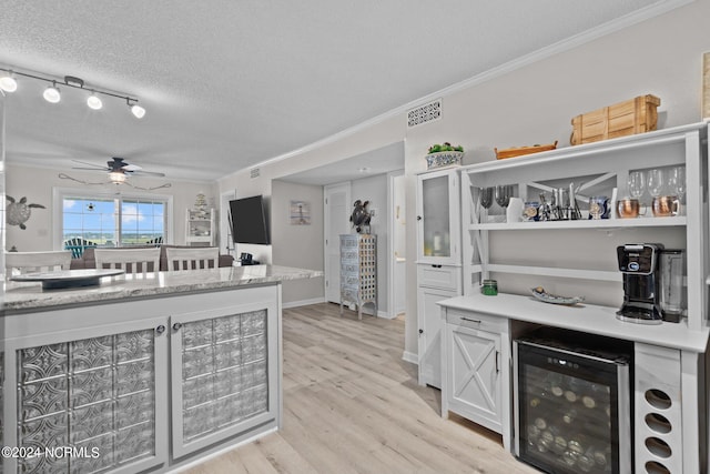 kitchen featuring ceiling fan, light hardwood / wood-style flooring, wine cooler, rail lighting, and a textured ceiling