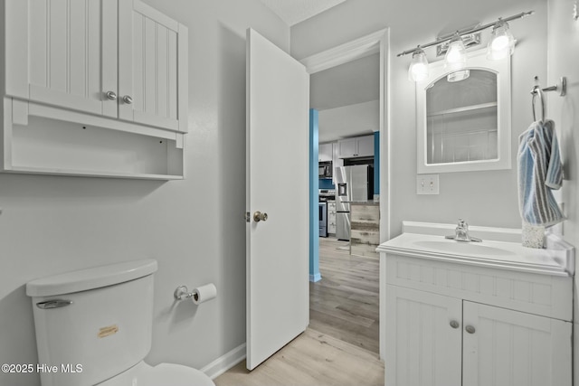 bedroom with a textured ceiling, ceiling fan, hardwood / wood-style floors, and ensuite bath