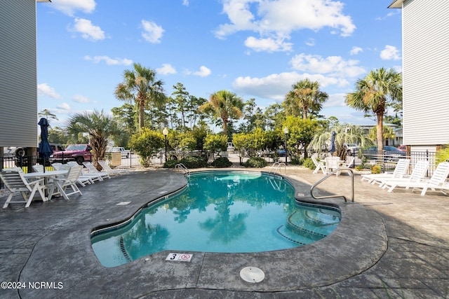 pool featuring a patio and fence