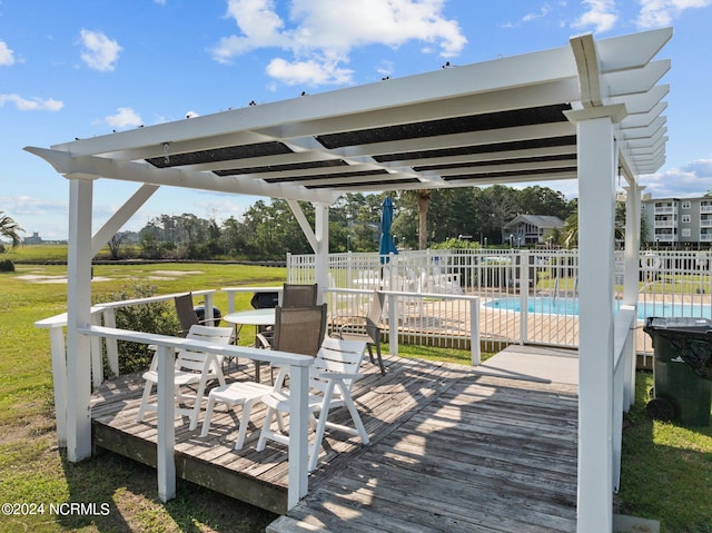 deck with a community pool, a pergola, and a yard