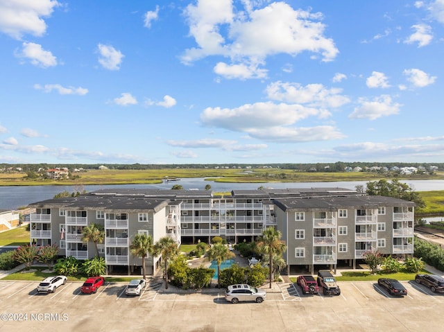 view of building exterior featuring a water view and uncovered parking