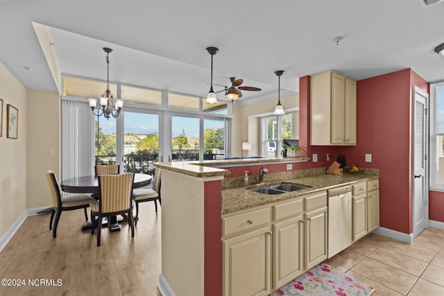 kitchen with pendant lighting, cream cabinetry, a sink, and stainless steel dishwasher