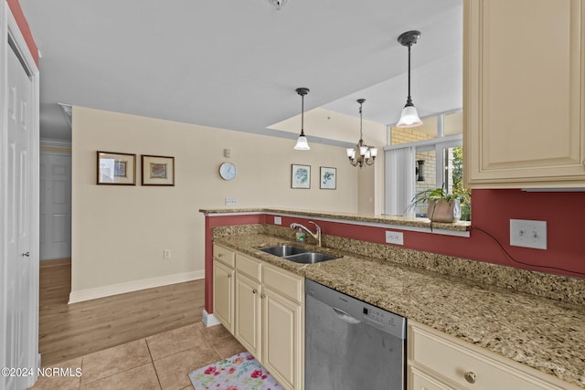 kitchen with light tile patterned floors, dishwasher, light stone counters, cream cabinets, and a sink