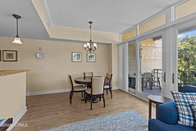 dining space featuring a chandelier, baseboards, and wood finished floors