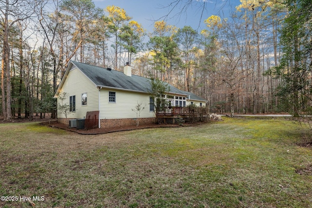 view of property exterior featuring a chimney, central AC unit, a lawn, and a wooden deck