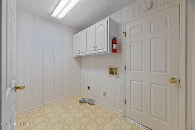 clothes washing area with a textured ceiling, hookup for a washing machine, hookup for an electric dryer, cabinet space, and wallpapered walls