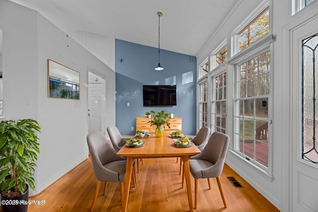 dining room with a healthy amount of sunlight, visible vents, baseboards, and wood finished floors