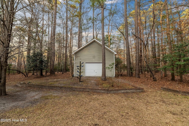 detached garage featuring dirt driveway