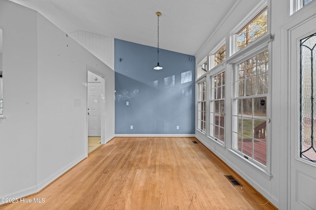 unfurnished dining area with light wood-style flooring, visible vents, and baseboards